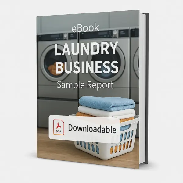 3D-rendered eBook cover for "Laundry Business Sample Report." The cover shows a modern laundromat with multiple stainless steel front-loading washing machines in the background. In the foreground, a white laundry basket is filled with neatly folded colorful towels. The title text reads “eBook LAUNDRY BUSINESS Sample Report” in bold white font, and a PDF icon with the word “Downloadable” is displayed at the bottom.