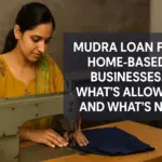 A South Asian woman in a yellow outfit works at a vintage sewing machine in her home-based workshop, with text overlay reading “Mudra Loan for Home-Based Businesses: What’s Allowed and What’s Not?” in bold modern font, emphasizing clarity on Mudra loan eligibility for small-scale home entrepreneurs.
