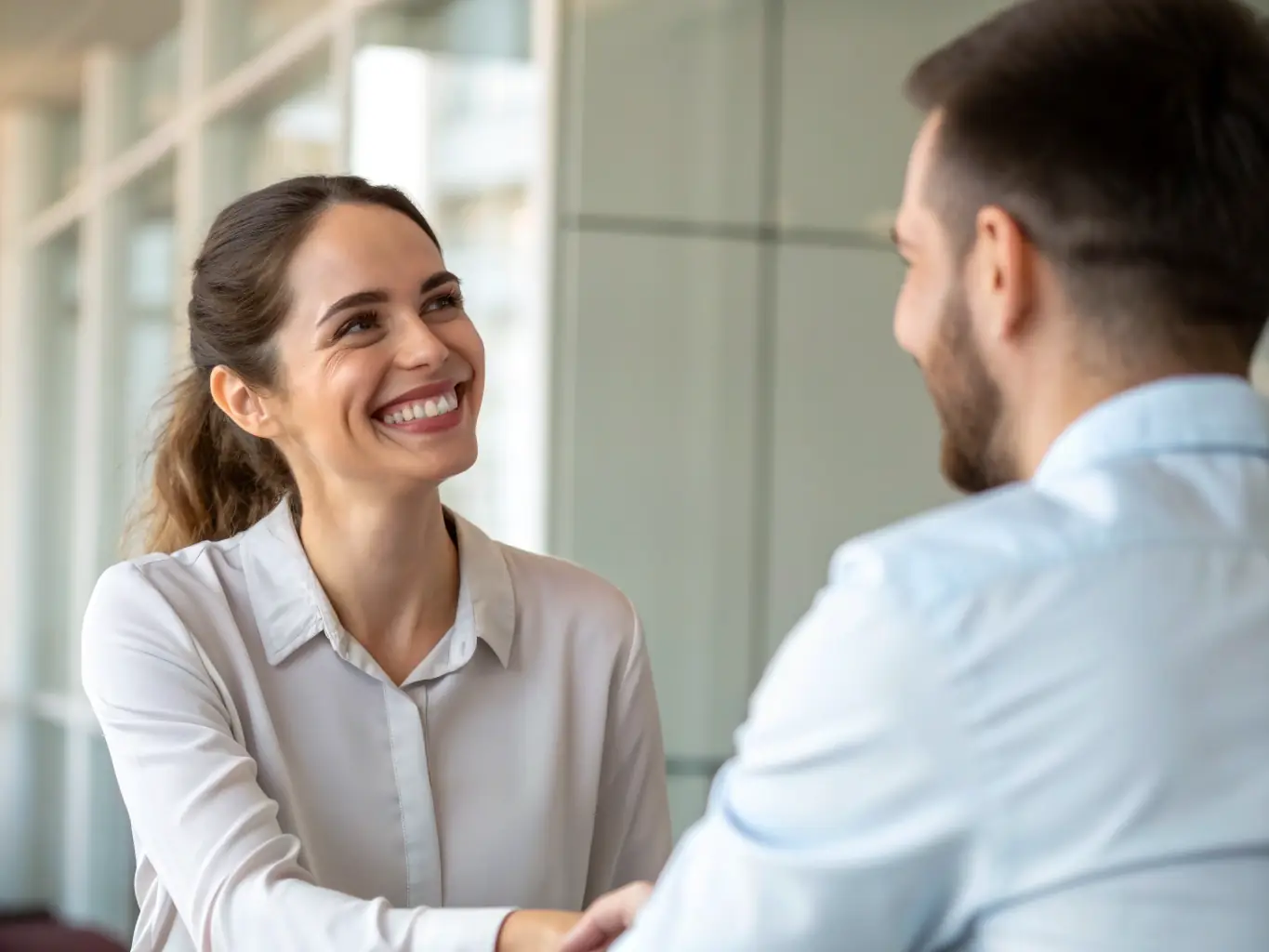 A close-up of a satisfied client shaking hands with a consultant, with a completed project report and approval stamp visible, symbolizing trust, success, and client satisfaction.